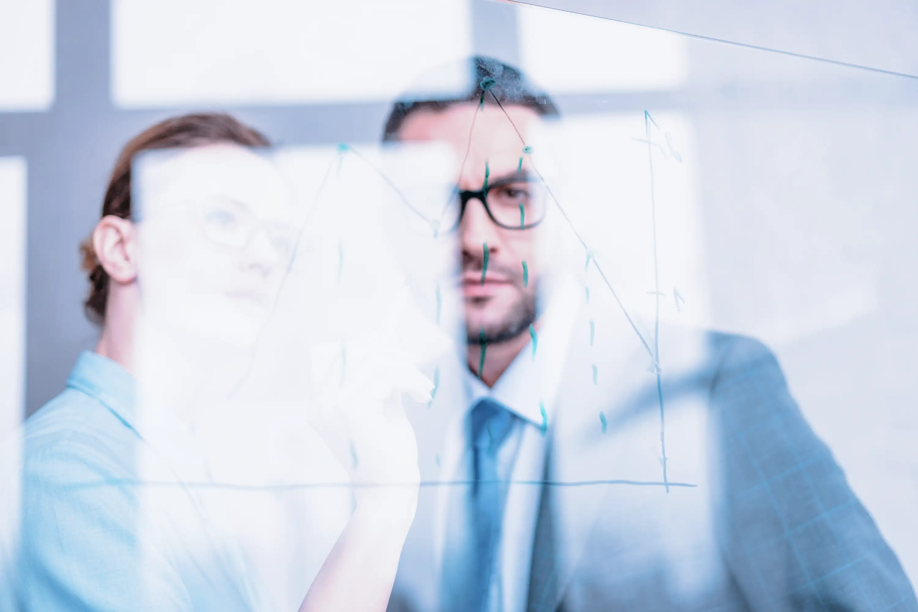 Colleagues assessing charts and graphs on a window