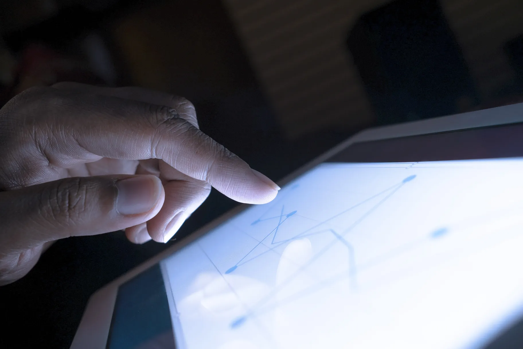Close up of hand interacting a tablet.