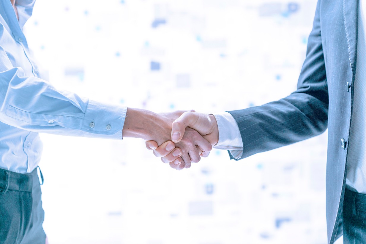 two workers handshake in agreement.