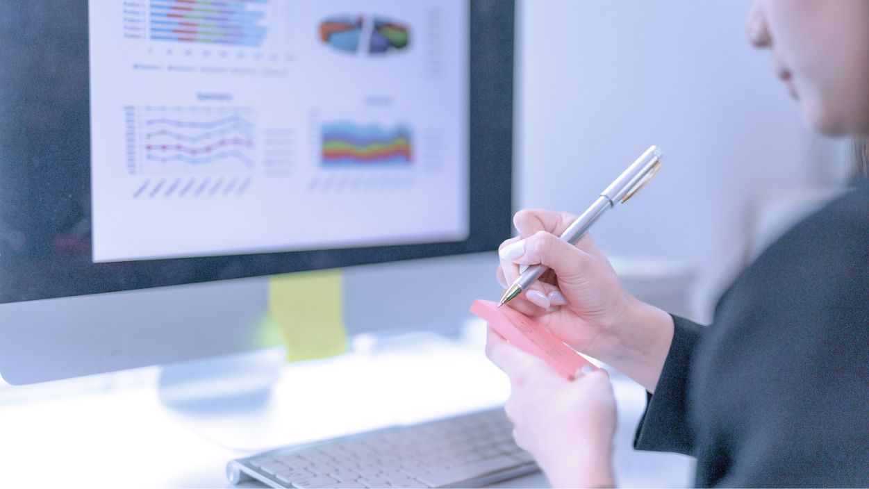 Student writing notes on a sticky pad.
