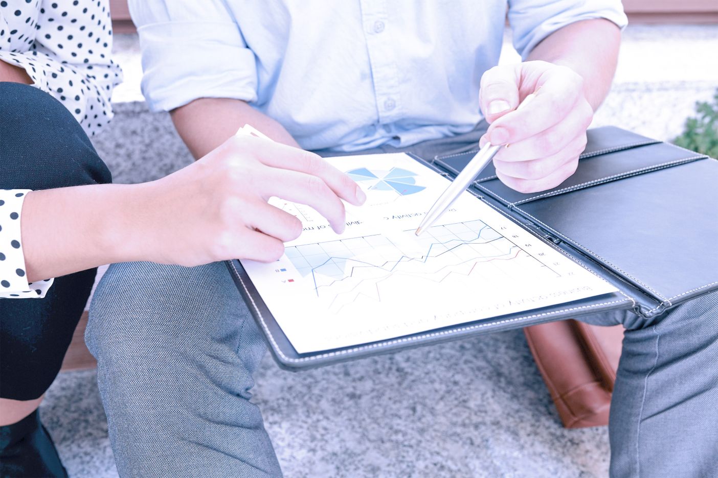 Colleagues assessing charts and graphs on a tablet.