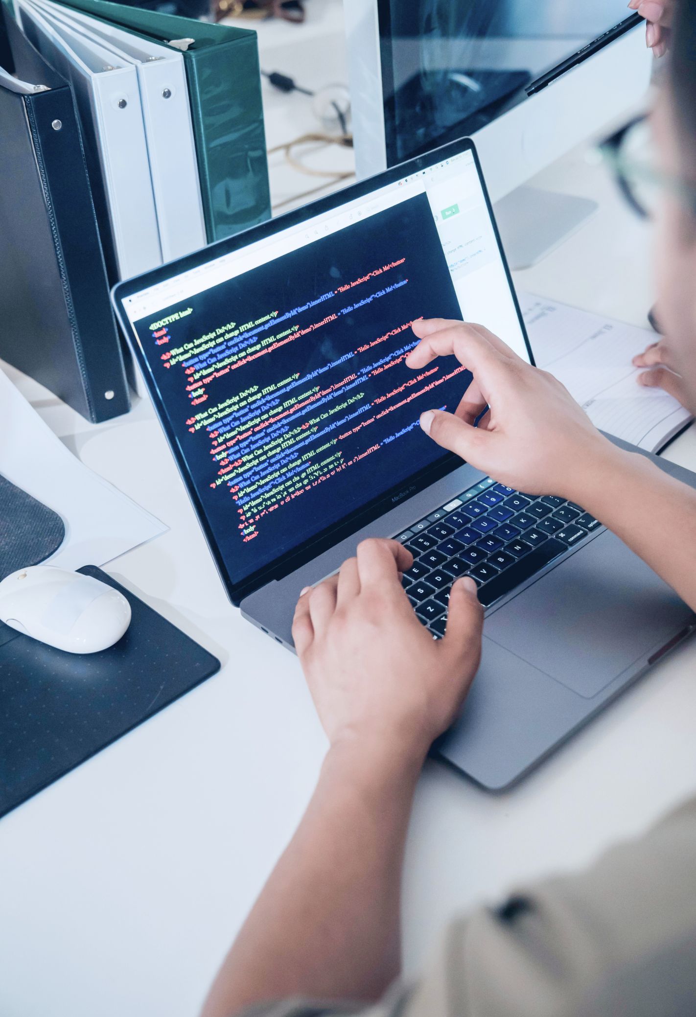 Over the shoulder shot of a programmer working on a laptop.