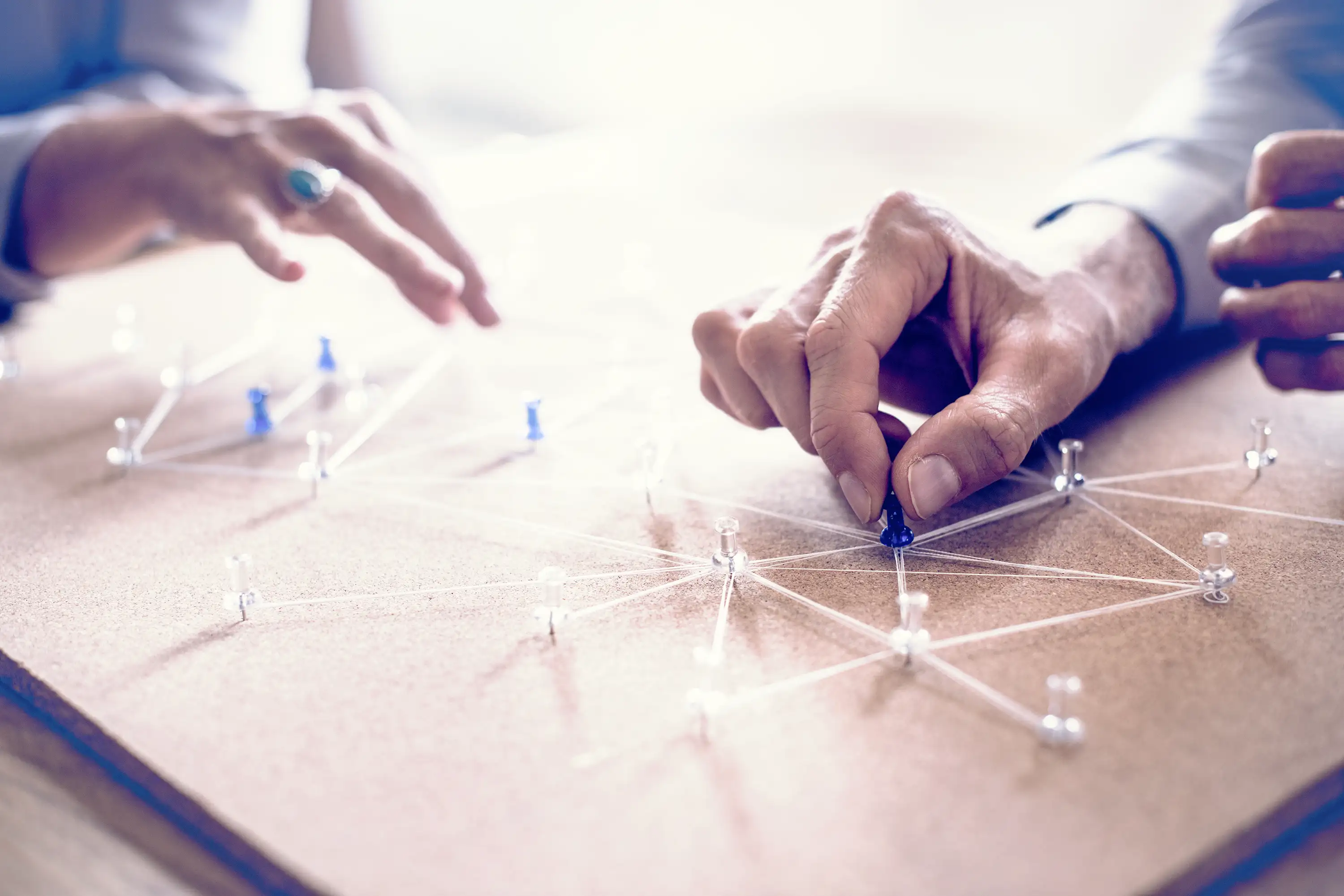 Colleagues setting up connection pins on a pinboard.