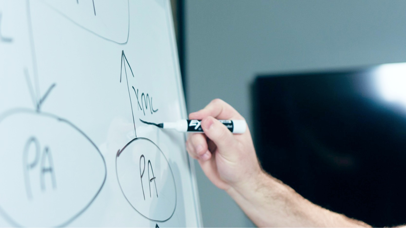 Man writing on a whiteboard. 