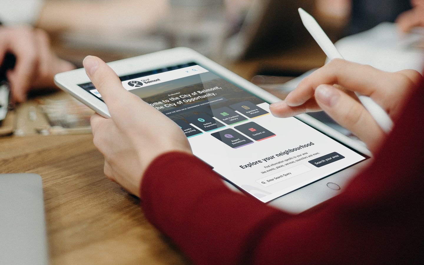 A close up shot of hands holding a tablet and stylus.