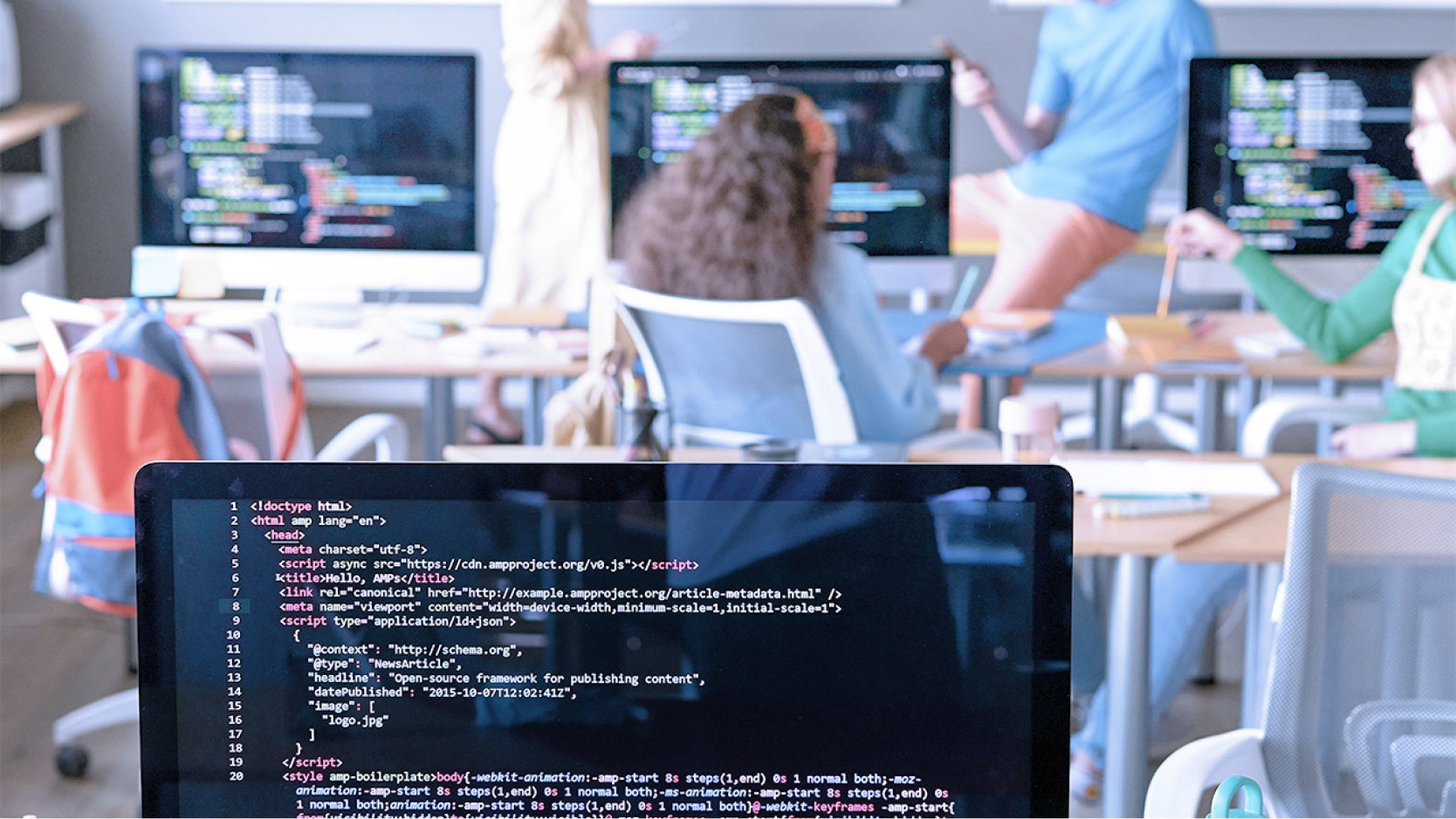 Image of main co-workspace area with colleagues in the background.