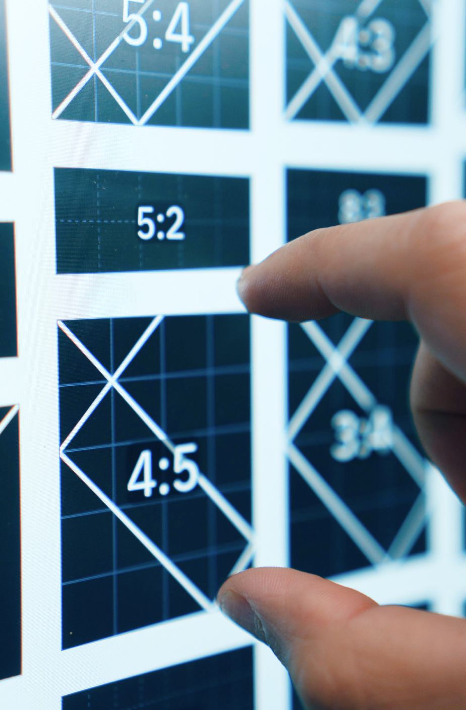 Designer pointing at image placeholder blocks on a screen.