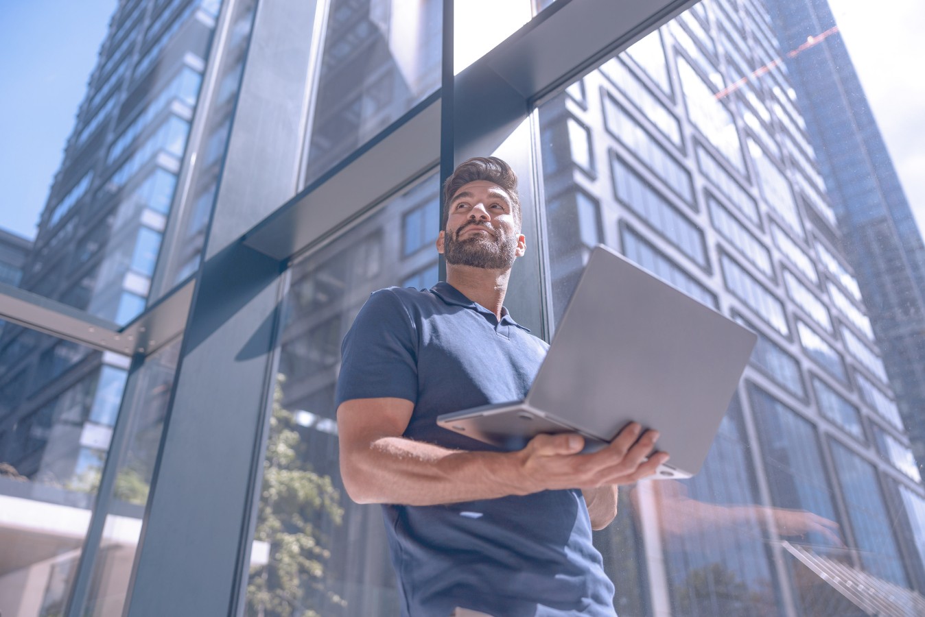 Man carrying laptop looking up. 