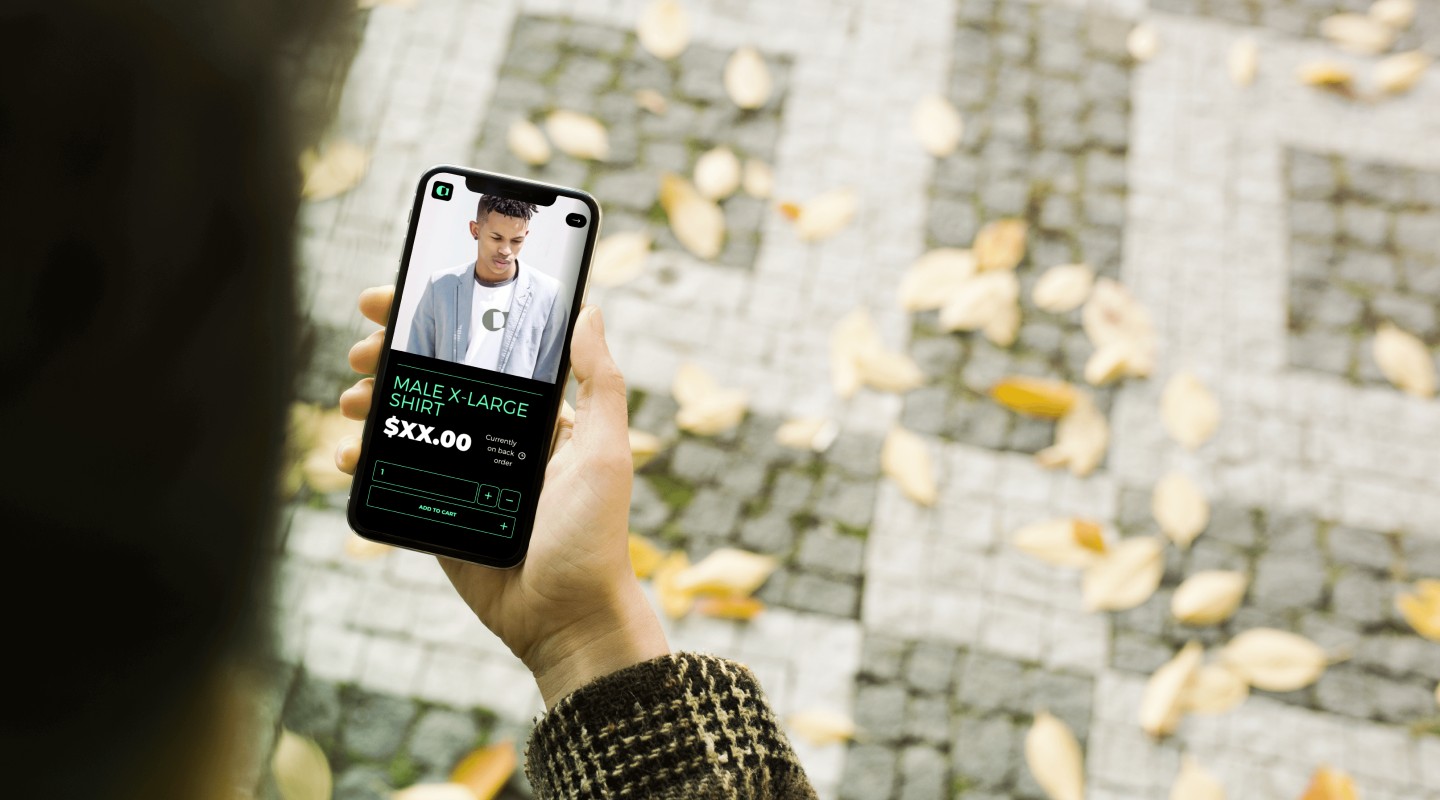 Person holding a smartphone outdoors, with e-commerce site displayed on screen