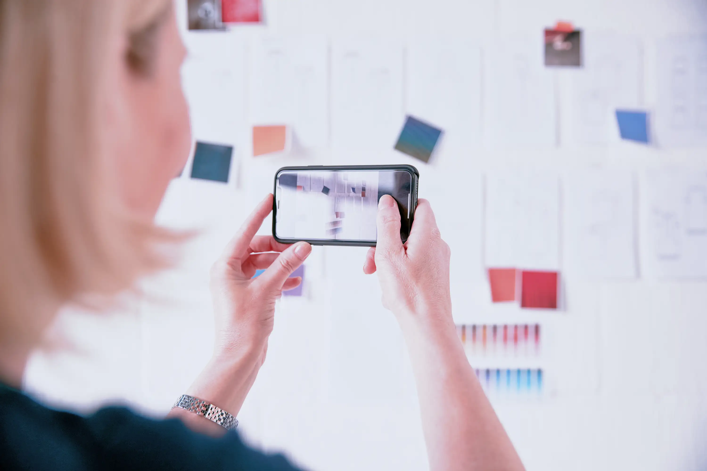 Colleague taking a picture of a workshop session whiteboard full of notes.