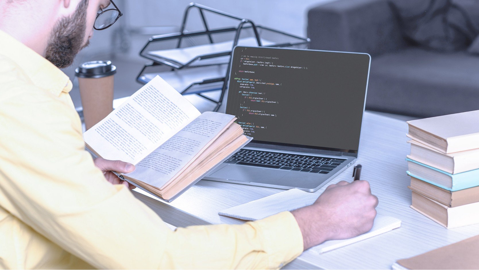 Student reading book and notetaking.