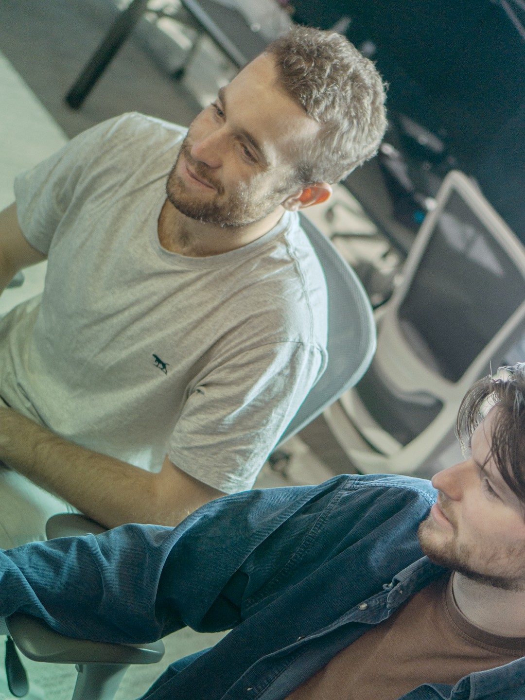 Two male staff looking at computer screen