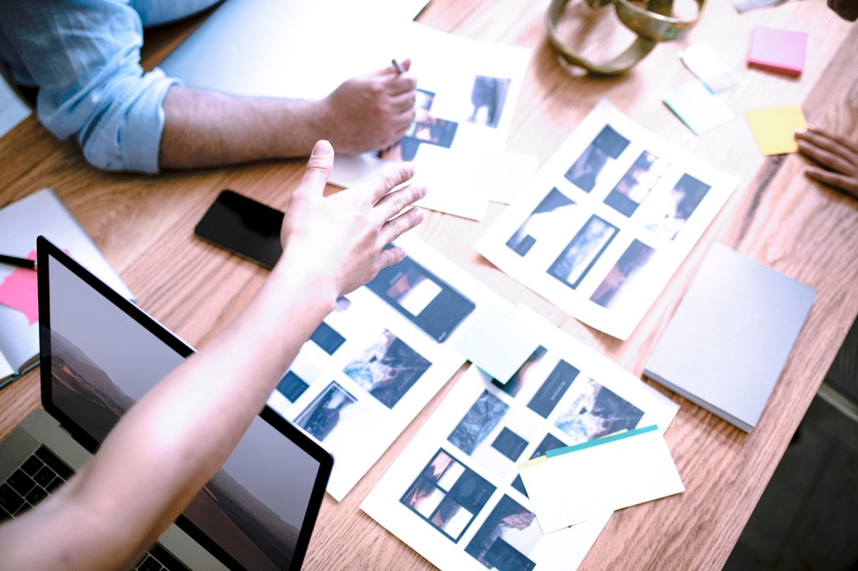 Multiple designers collaborating on a workspace table top down view.