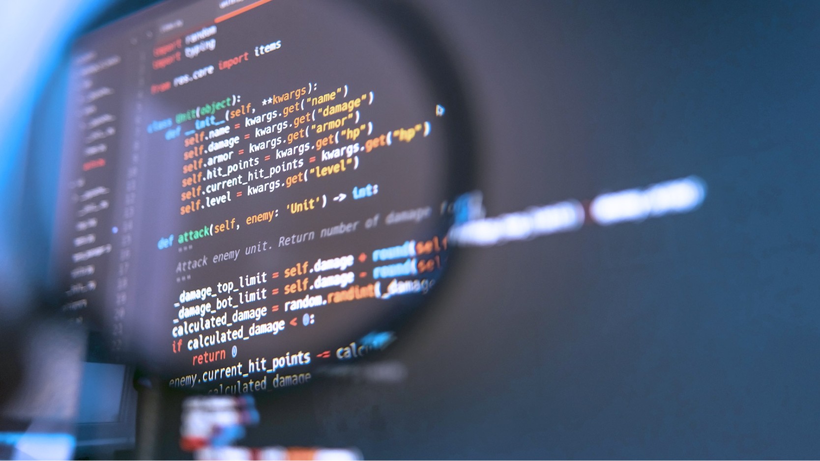 magnifying glass against a laptop screen showing lines of code