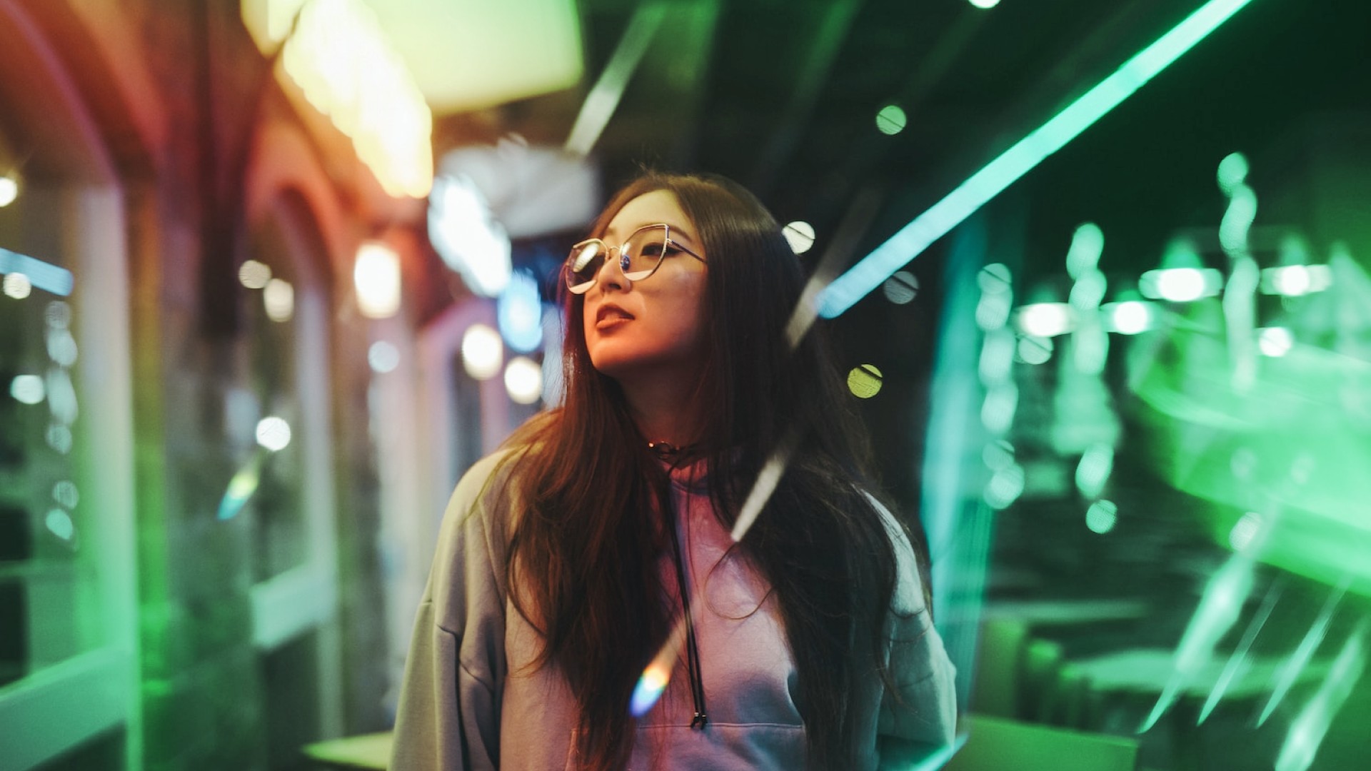 Woman walking in a street with reflection of street lights on her