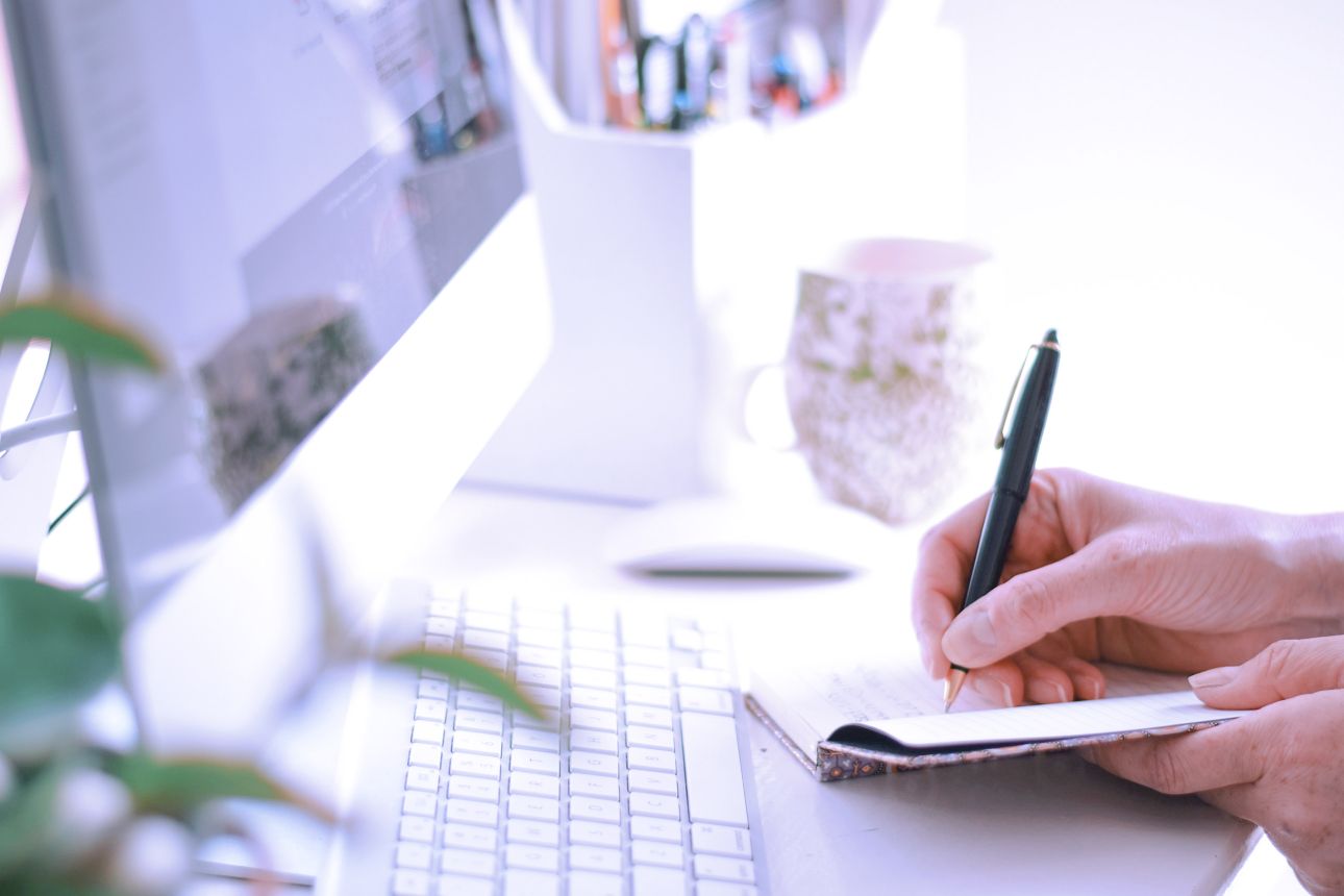 Project manager writing a brief on a notepad.