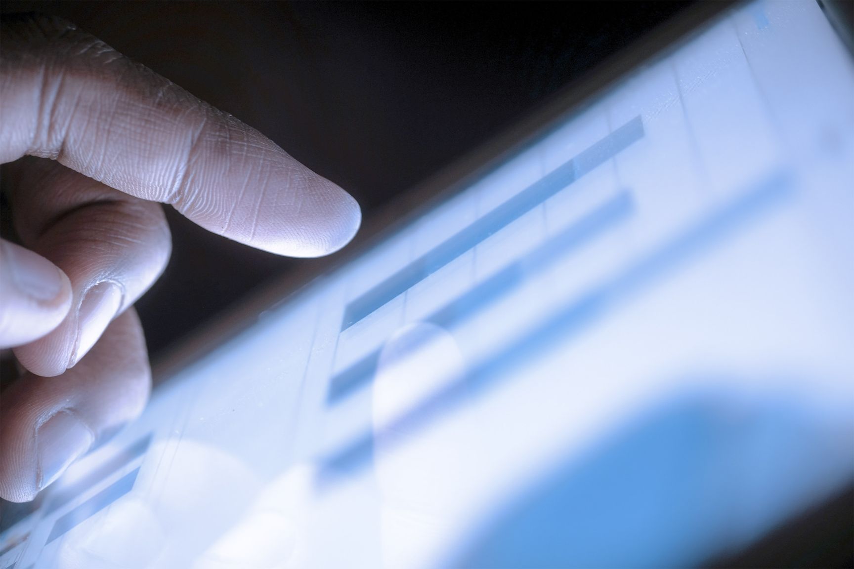 Close up of hand interacting with tablet.