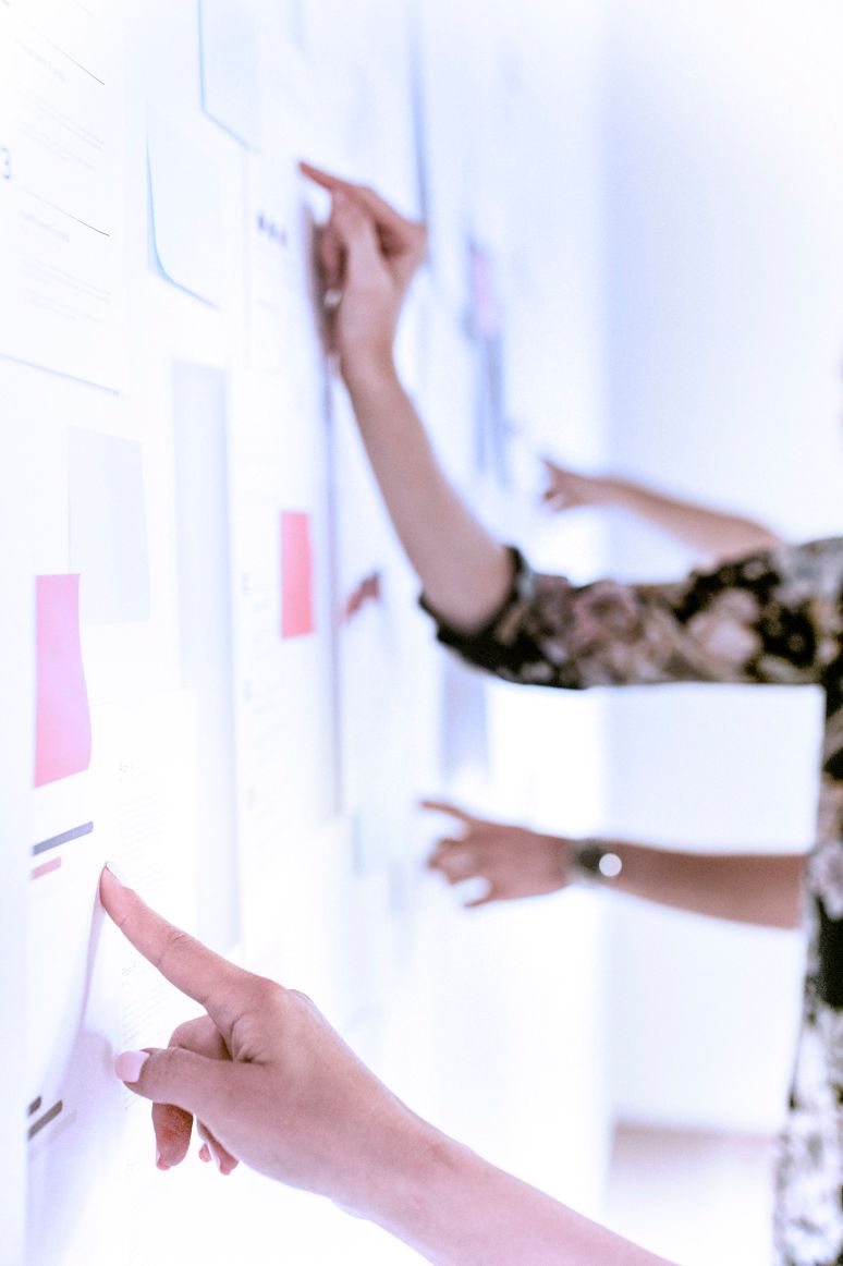 Colleagues reviewing together user flows on a whiteboard.