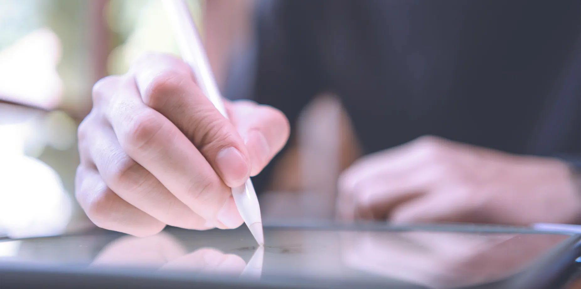 Close up of hand with stylus; drawing on tablet 
