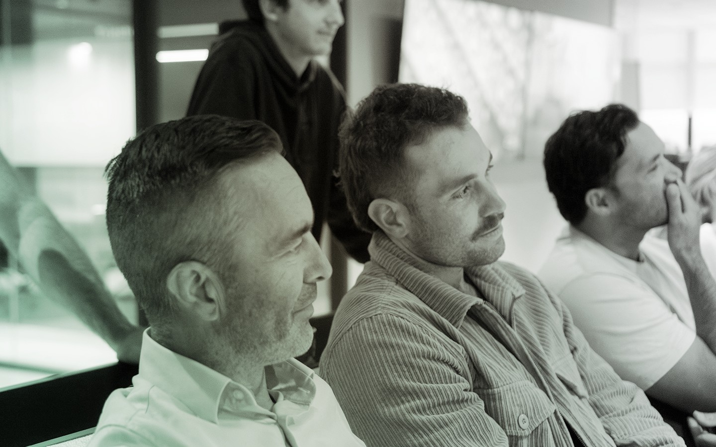 Photo of four male staff in a team meeting