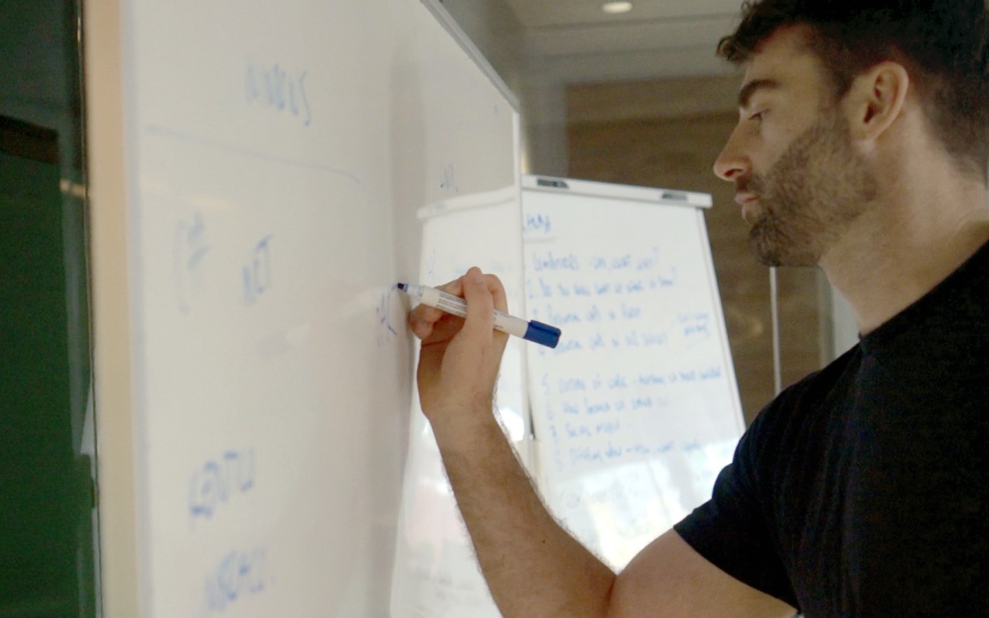 Man writing on whiteboard during work meeting