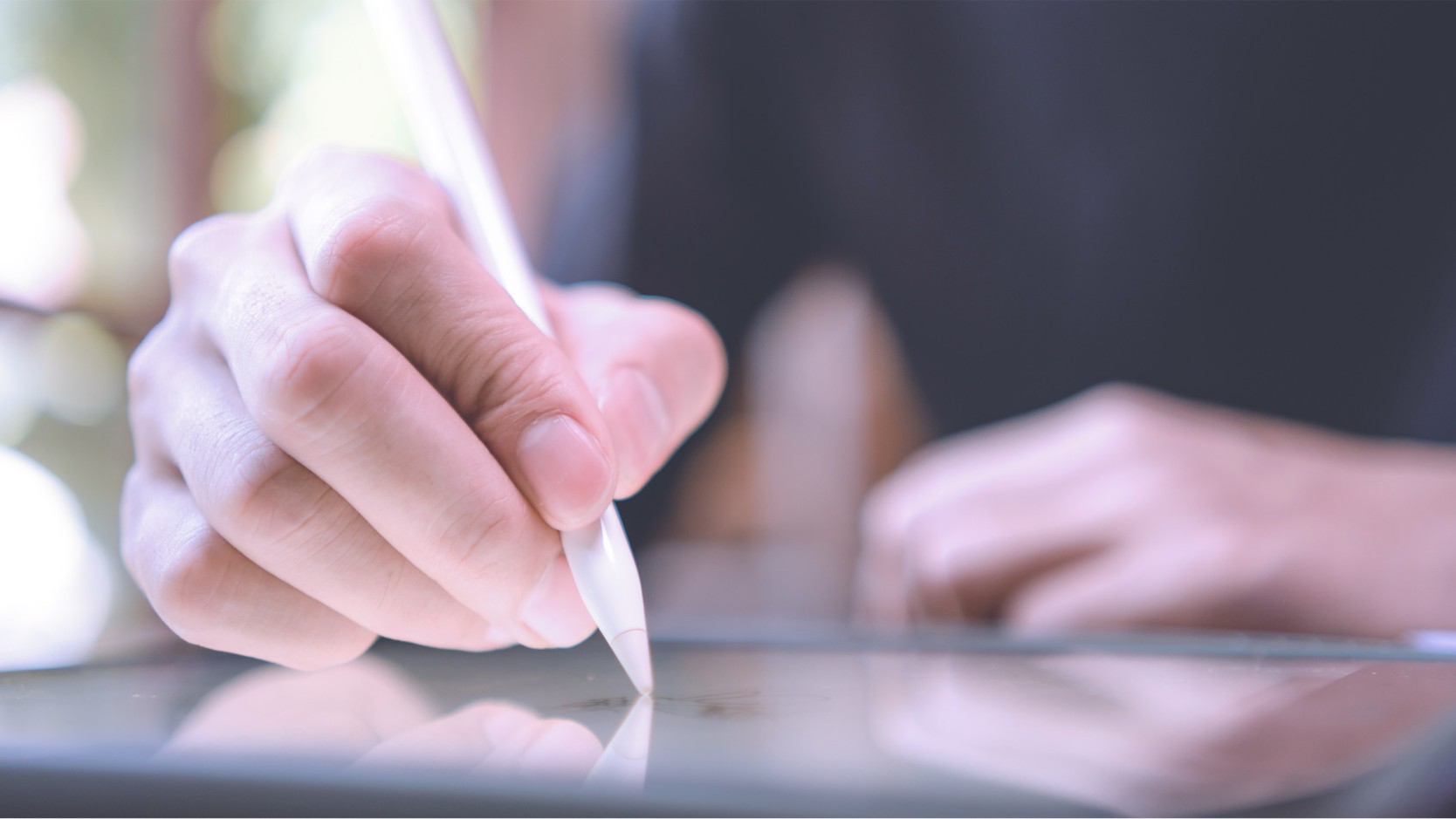 hand holding a stylus on a tablet 