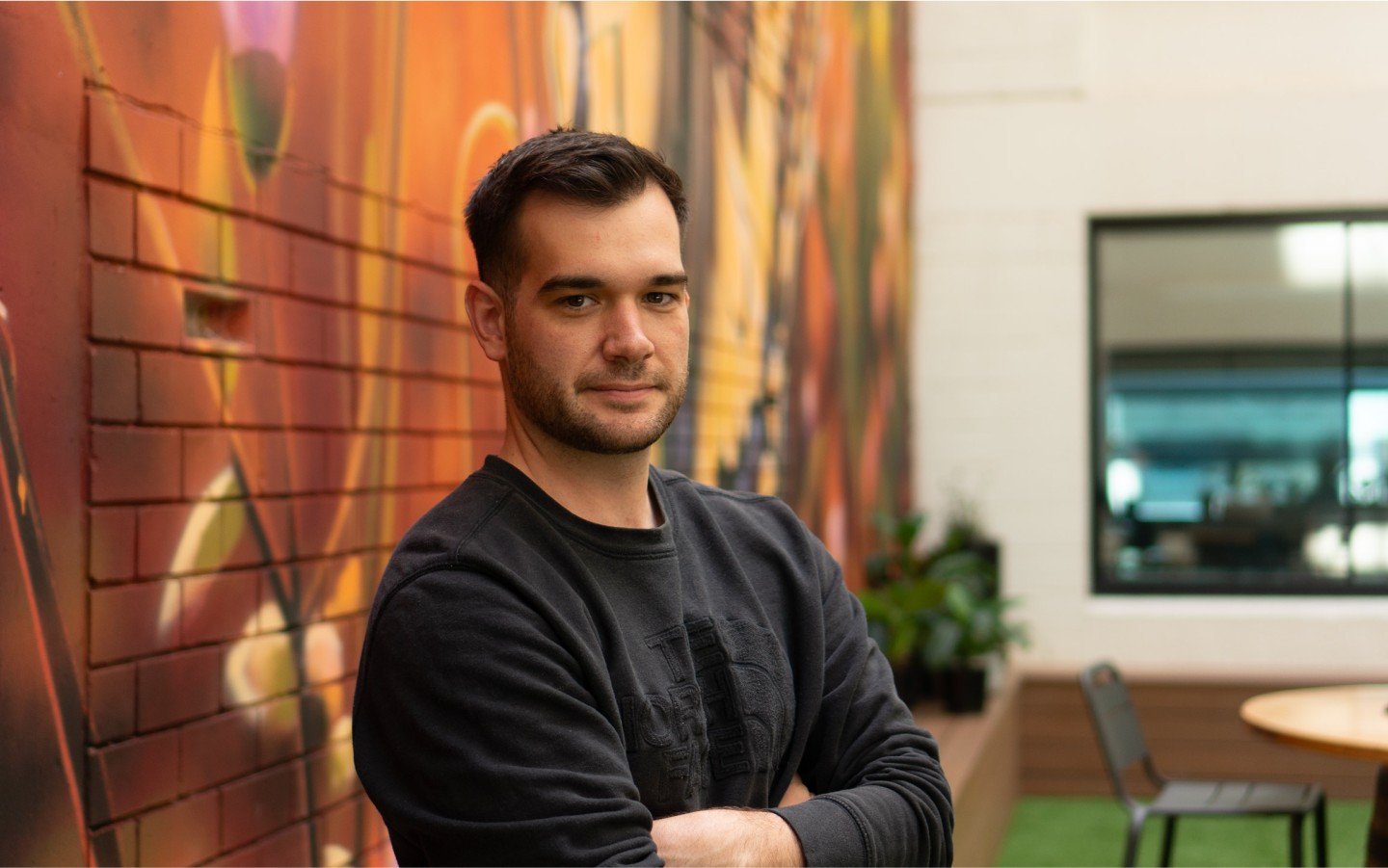 Image of a man against illustrated mural wall