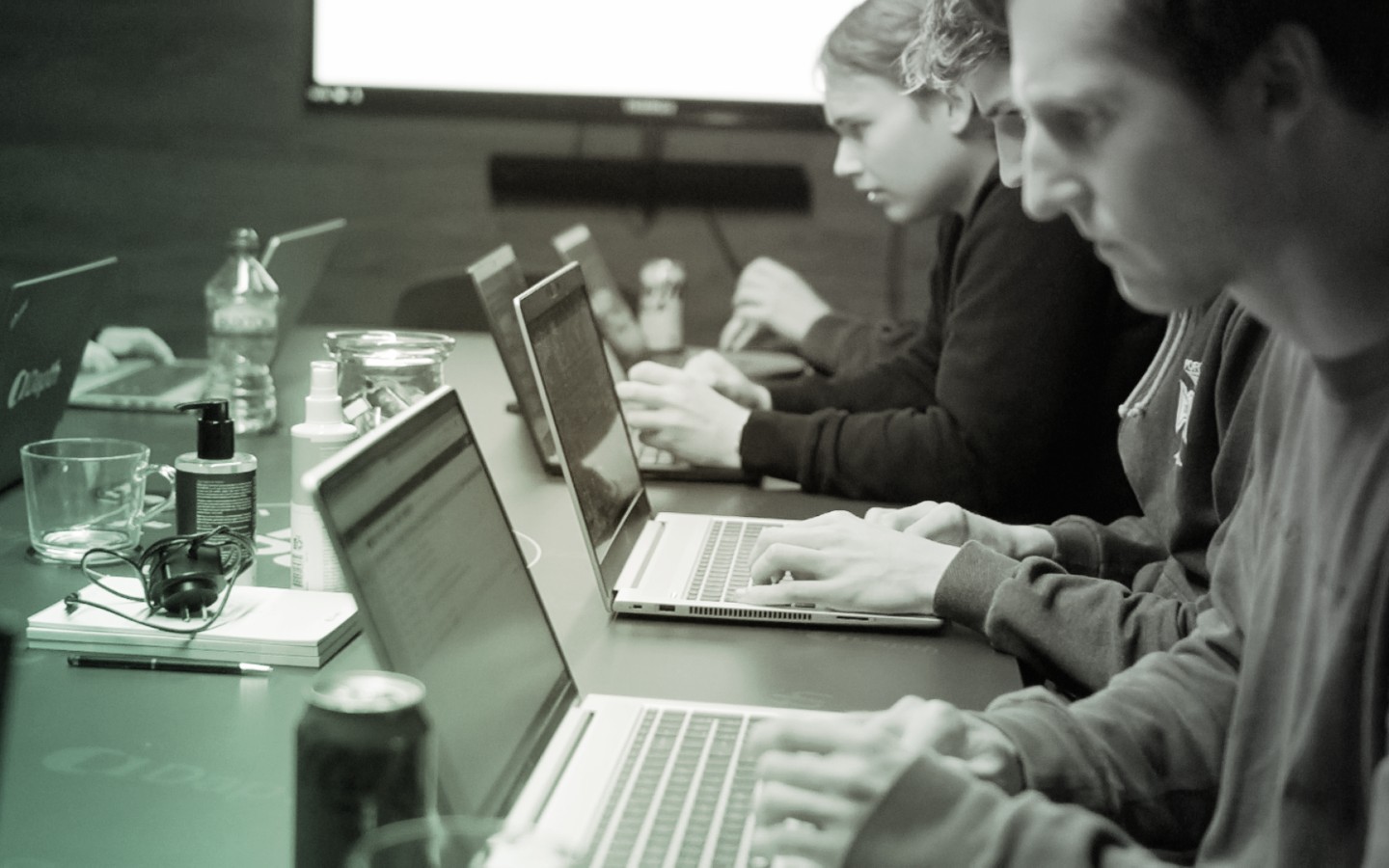 Staff in a meeting looking at laptop screens