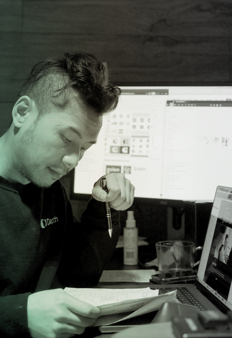 Man reading work papers with screens in background