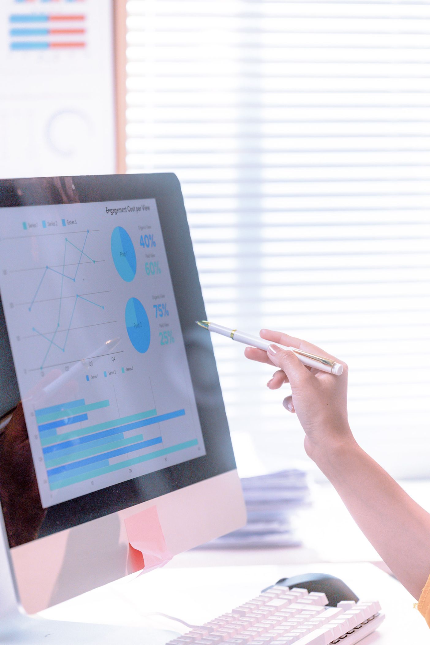 Worker assessing charts and graphs with a stylus on a computer screen