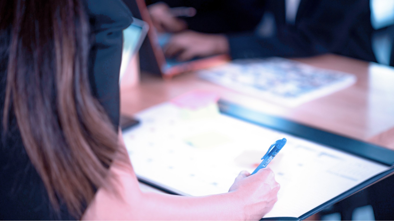 Worker writing on a planner.