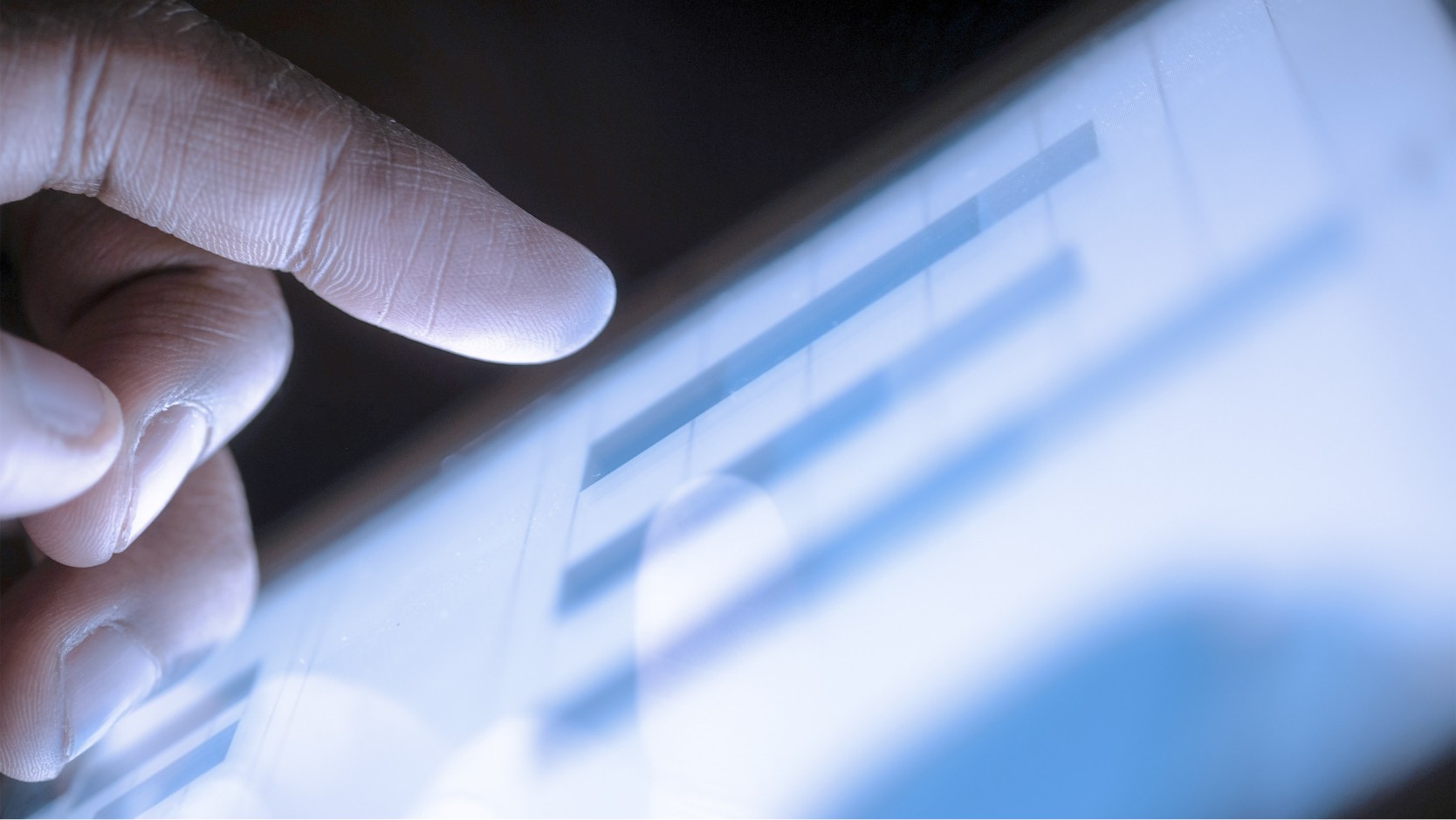 Close up of hand interacting with tablet.