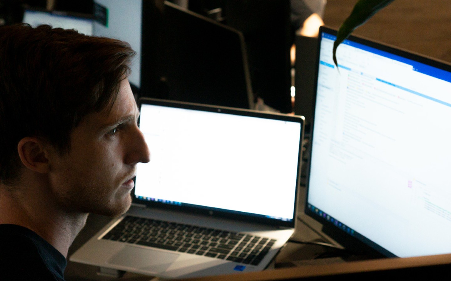 Male staff looking at two computer screens