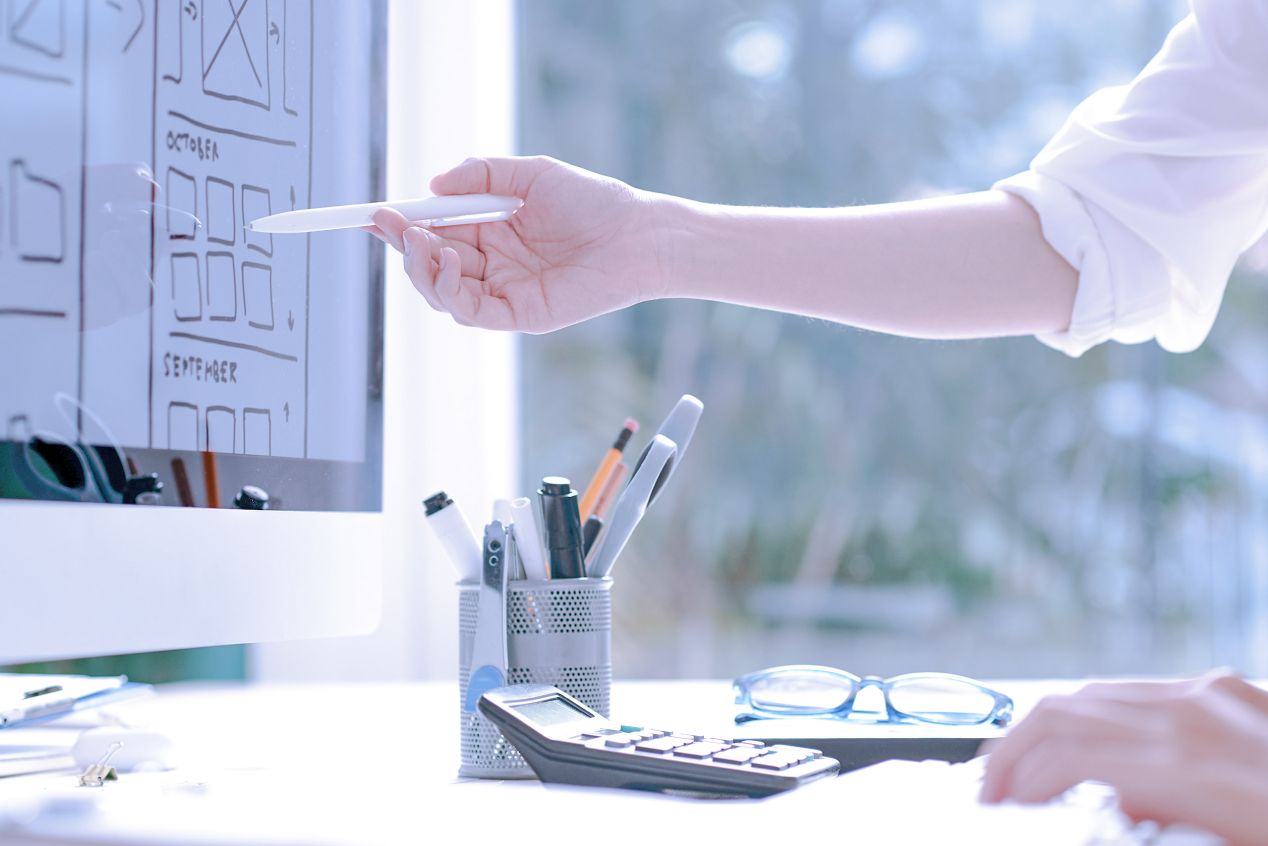Colleague pointing at a wireframe on computer screen