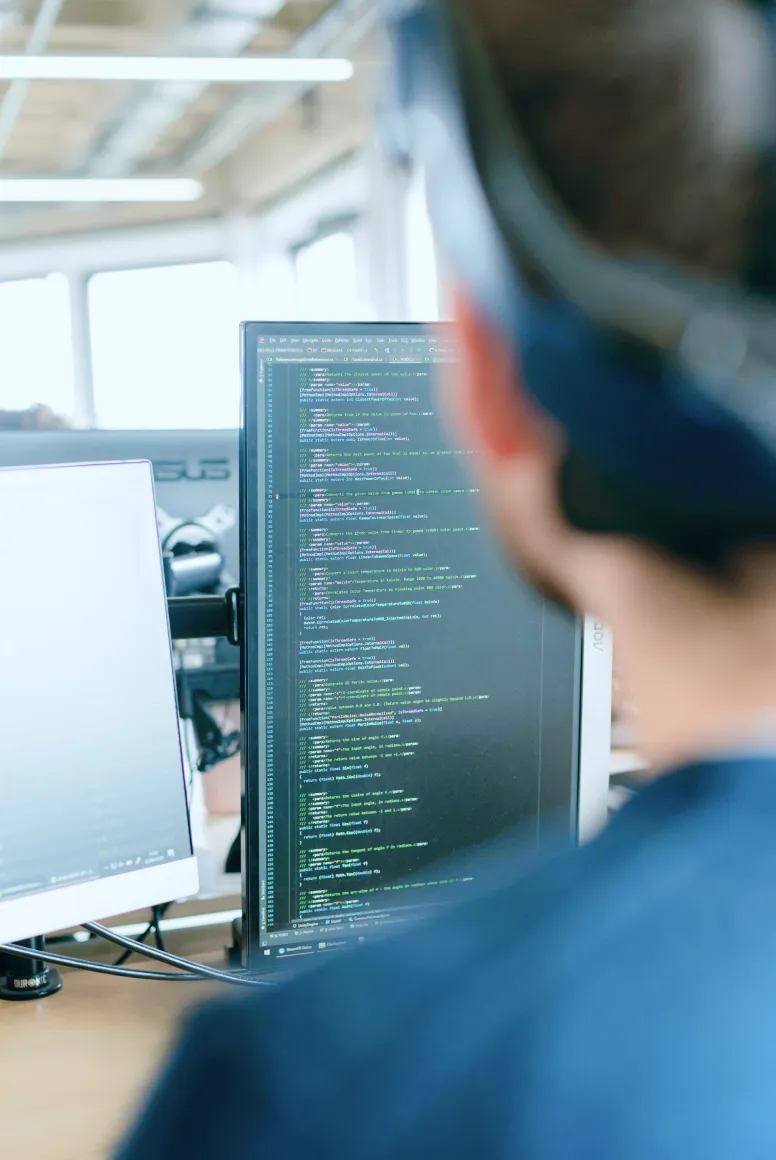 Developer inspecting lines of code on a vertical monitor