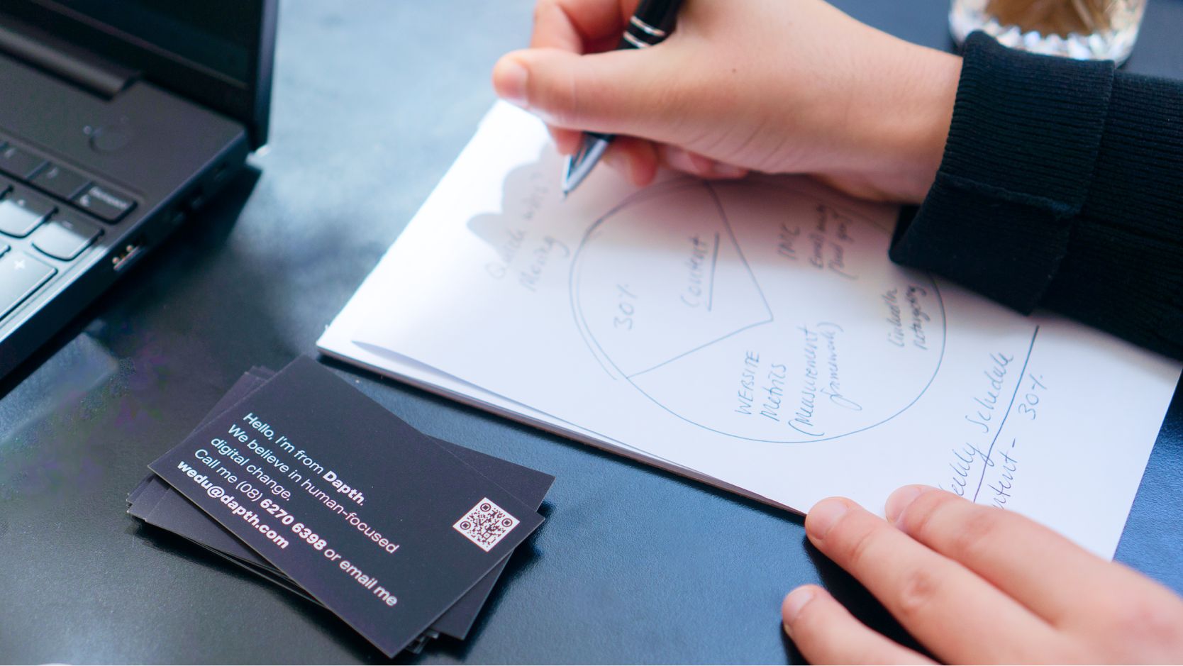 Planning and writing a strategy on a notepad.