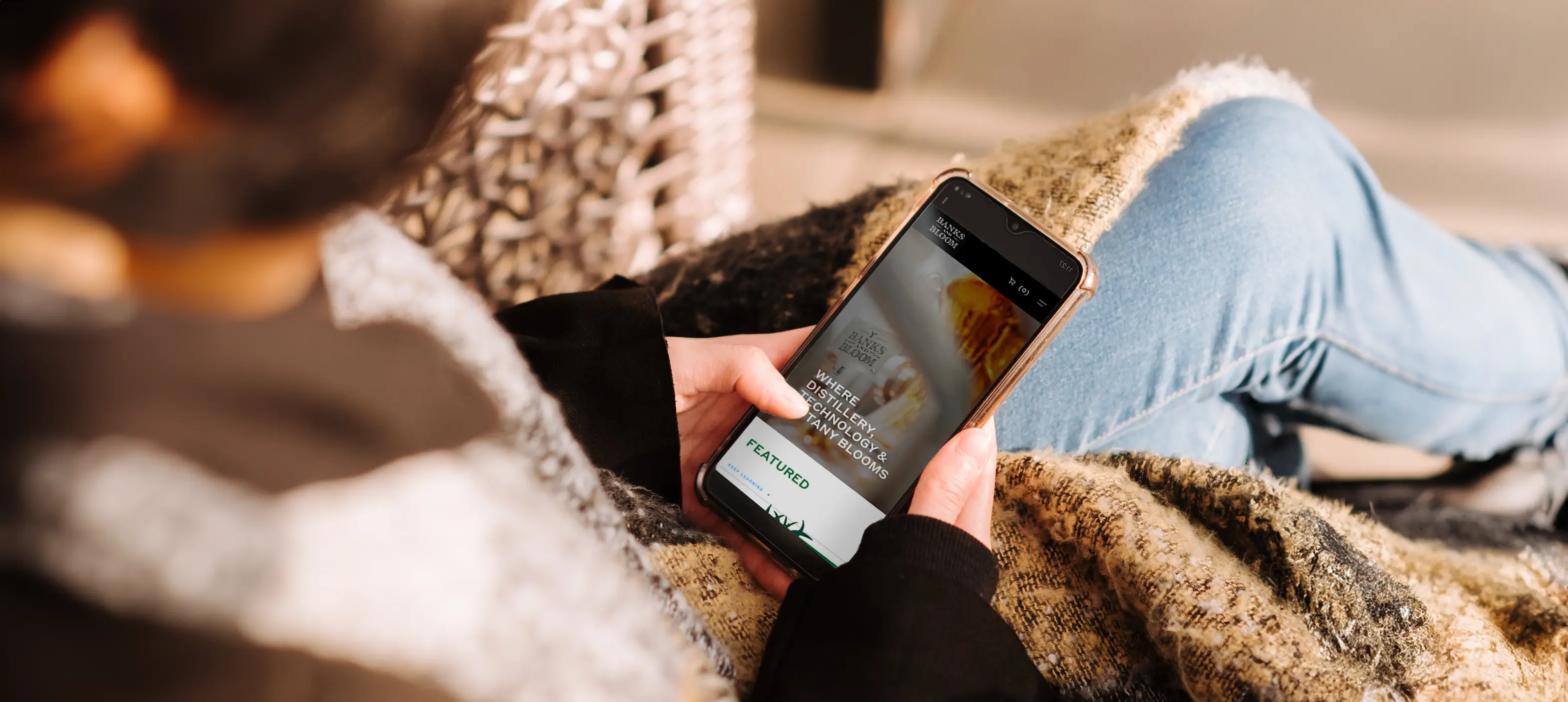 Woman sitting down on a couch browsing on a smartphone.