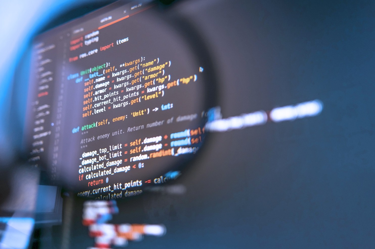 magnifying glass against a laptop screen showing lines of code