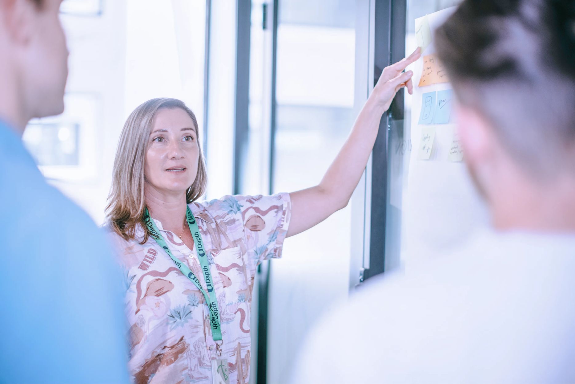 Senior strategist reviewing sticky notes on a wall