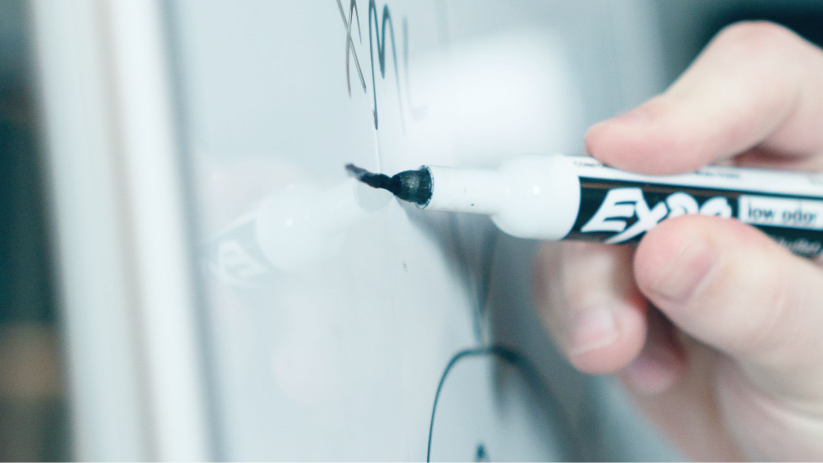 Man writing on a whiteboard. 